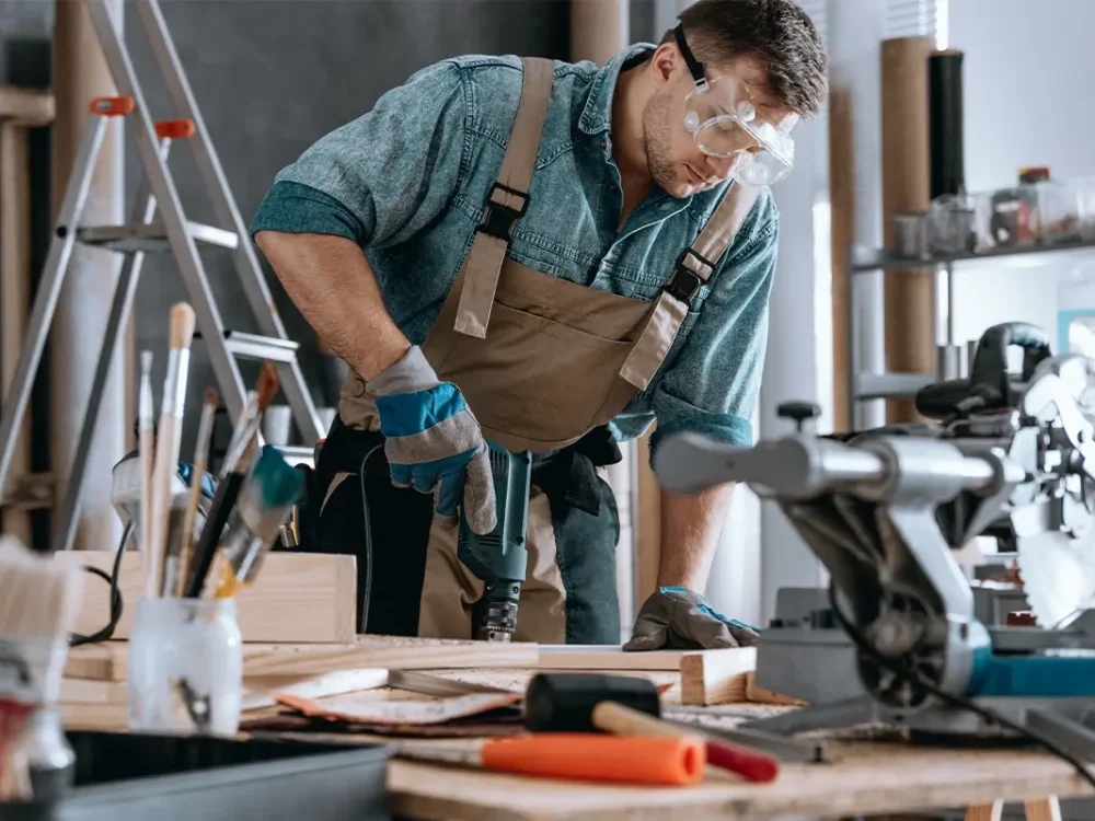 Insurance-by-Industry-Young-contractor-drilling-hole-in-his-personal-workshop